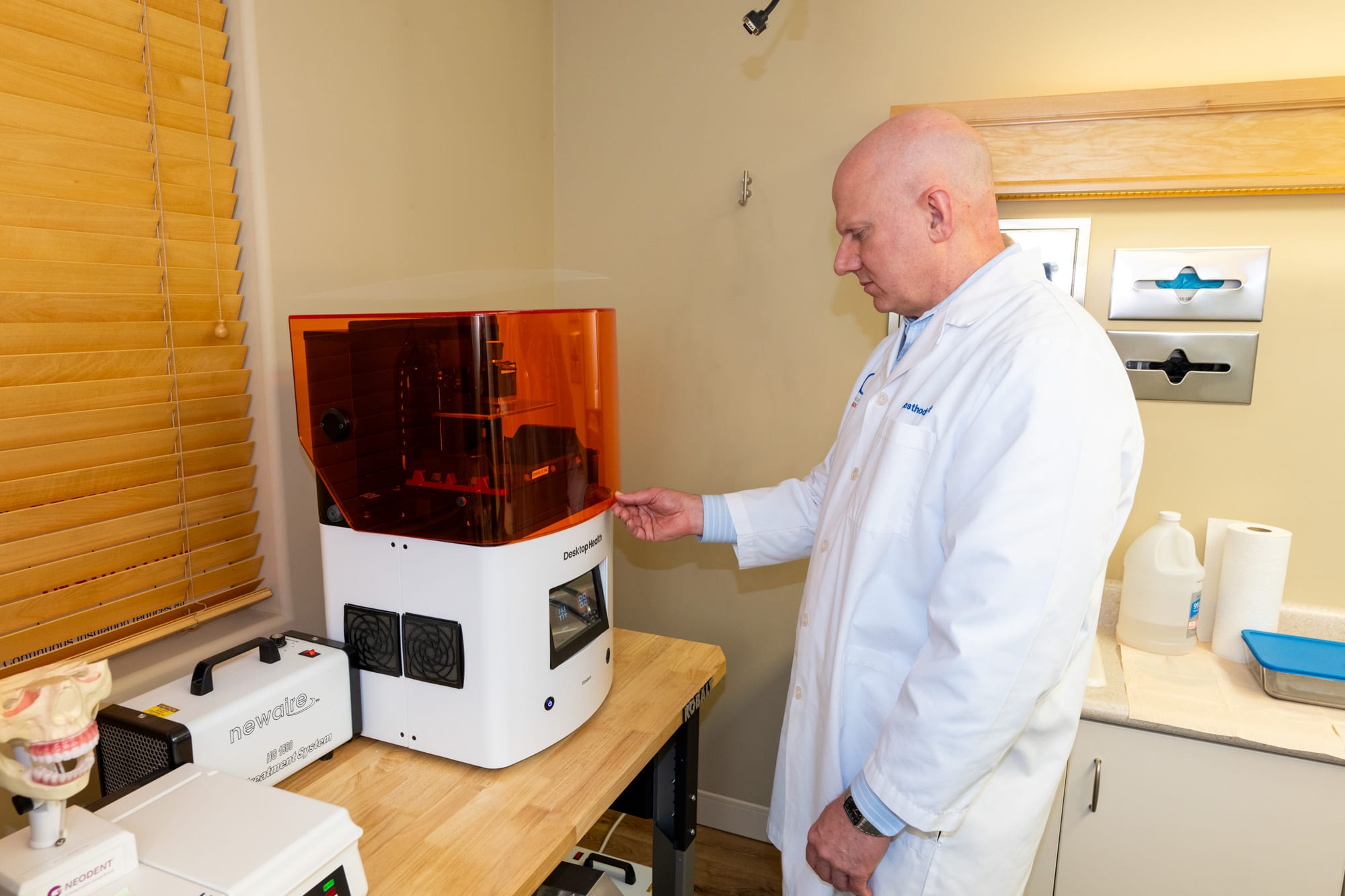 Dr. Andrus next to the Einstein 3D printer used to fabricate diagnostic prototypes in-house