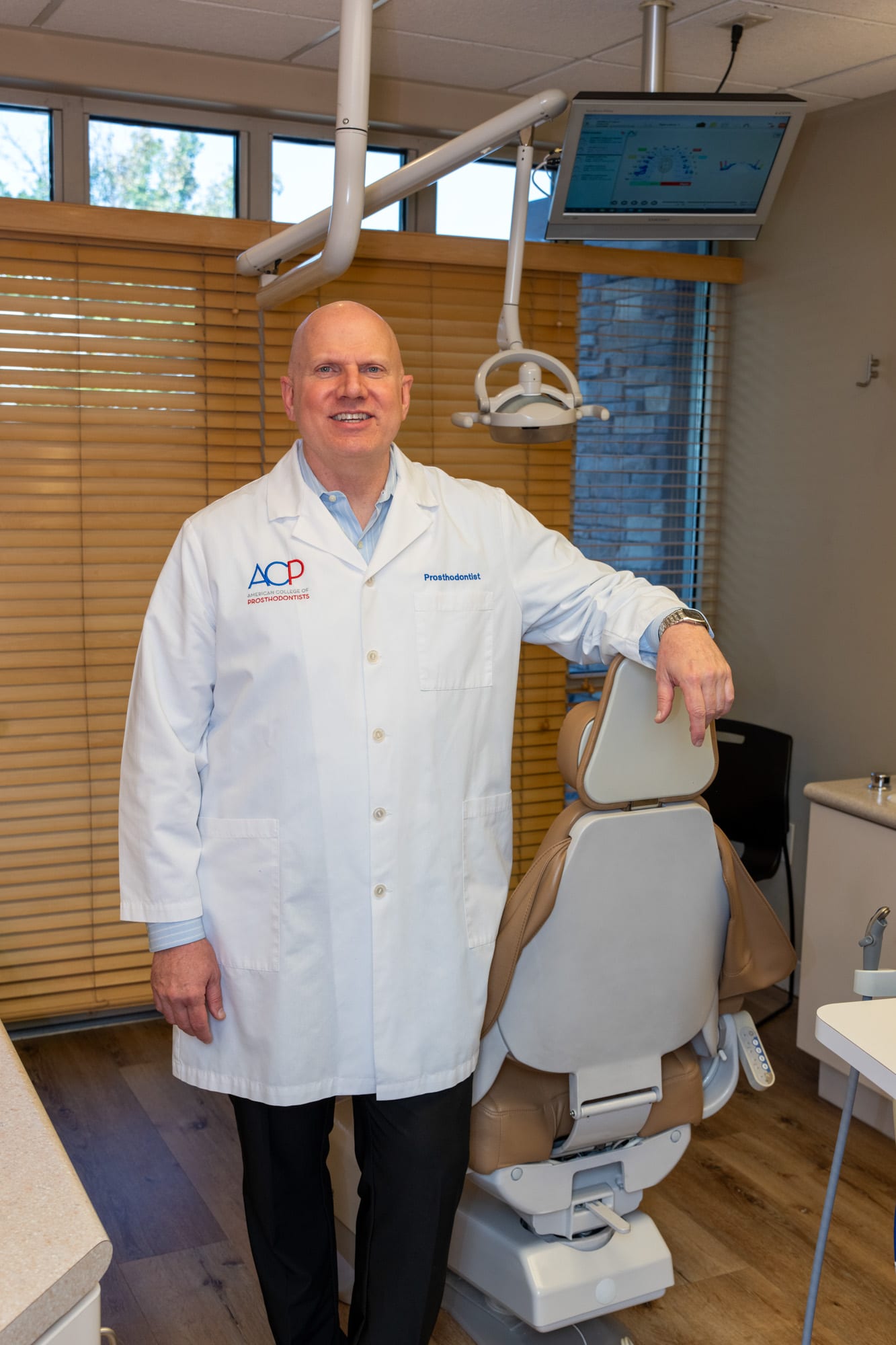 Dr. Andrus in the operatory with a T-Scan digital bite analysis displayed on the overhead screen
