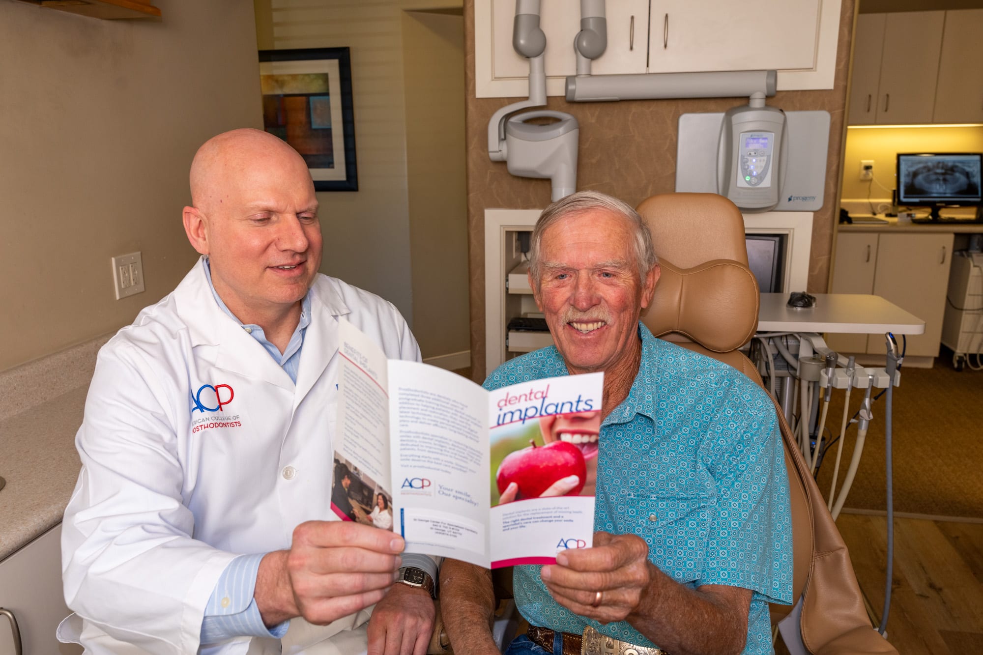 Dr. Andrus reviewing dental implant options with a patient chairside